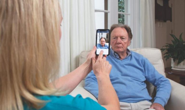 Image showing man having photo taken by care professional.