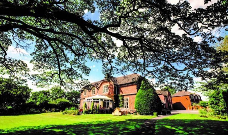 Old Rectory, a Care Home in Staffordshire, surrounded by trees and grass