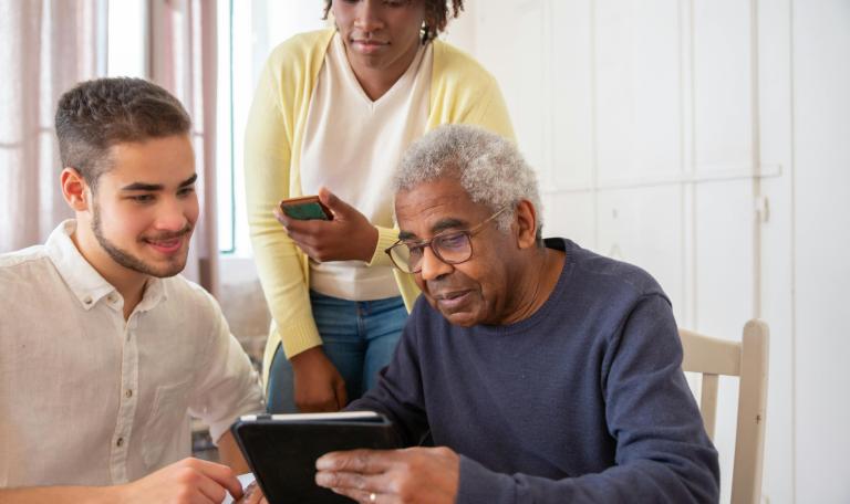 three people using digital devices in care