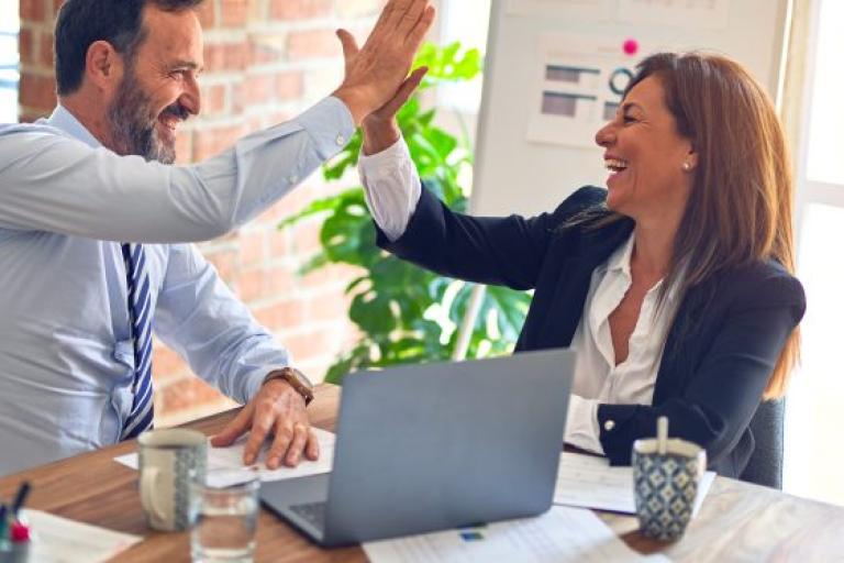 Two people high fiving during business conversation
