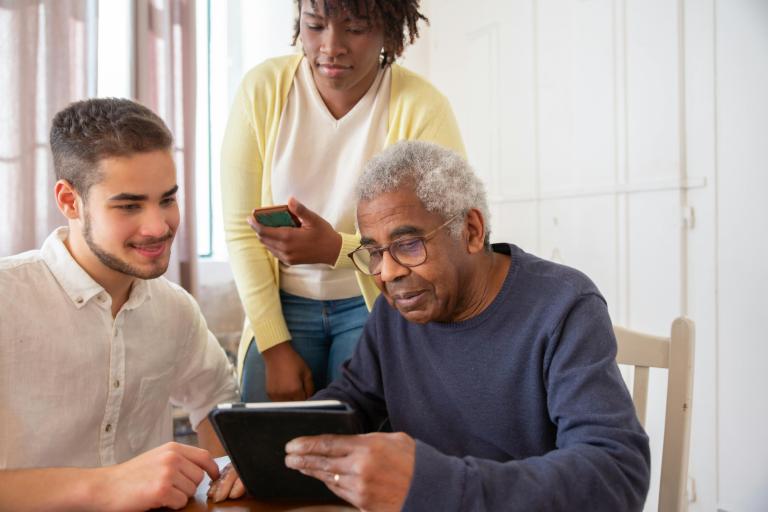 three people using digital devices in care